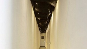 A long, narrow hallway with a shiny floor and white walls. - Bushe Cuoguo Inn (Xiamen)