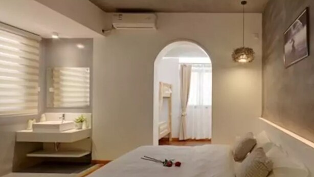 A modern bedroom with a large bed, bedside table, and a mirror. - Bushe Cuoguo Inn (Xiamen)