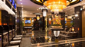 A modern lobby with a central chandelier, a reception desk, and a seating area with patterned chairs. - APA Hotel & Resort Nishishinjuku Gochome Ekimae Tower (Tokyo)