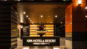 The entrance of APA HOTEL & RESORT with a signboard, a flower arrangement, and a well-lit pathway. - APA Hotel & Resort Nishishinjuku Gochome Ekimae Tower (Tokyo)