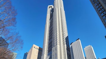 Un rascacielos alto y moderno con un diseño arquitectónico único, rodeado de otros edificios de gran altura.