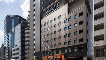 A modern hotel with multiple floors, a prominent sign, and a visible entrance.