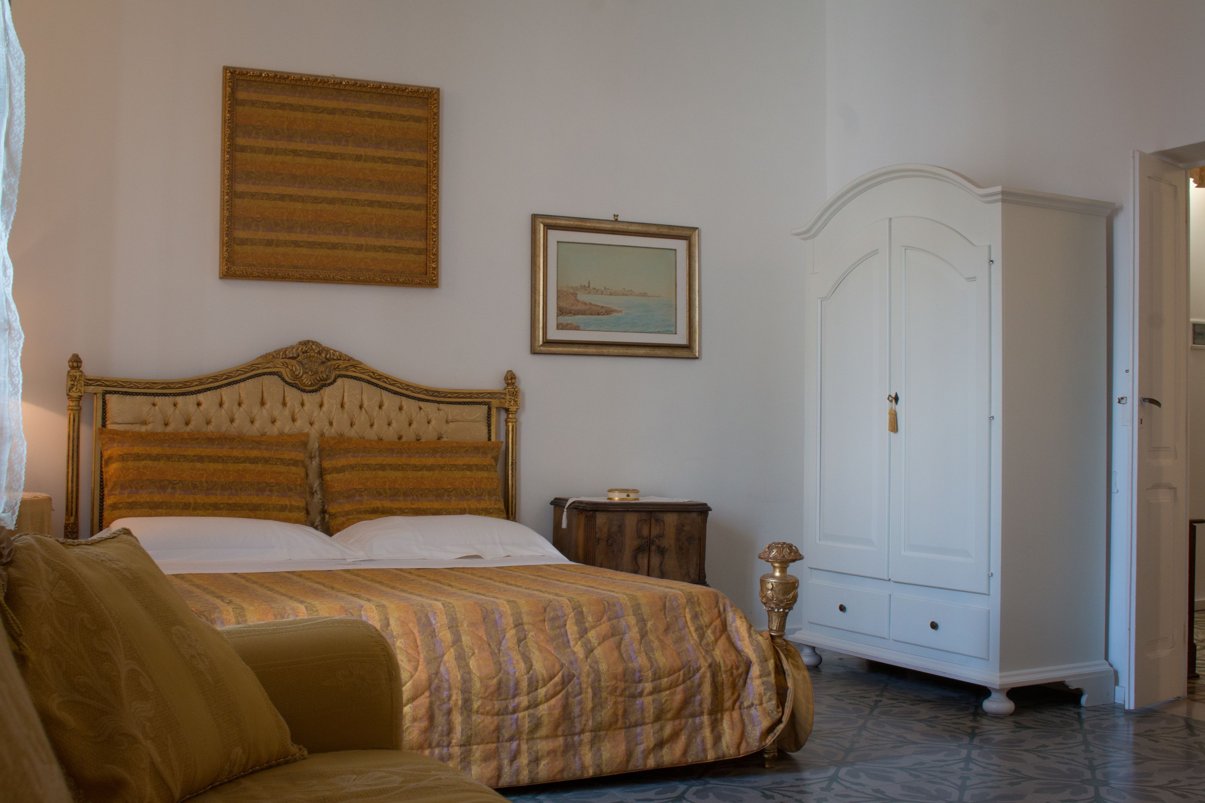 Quarto com cama grande, guarda-roupa e um quadro na parede.