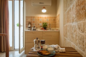 A kitchen with a wooden table, a coffee maker, a plate with toast, and a glass of milk.