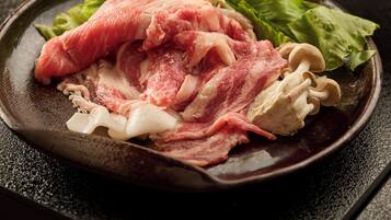 Une poêle contenant de la viande crue, des champignons et des légumes verts.