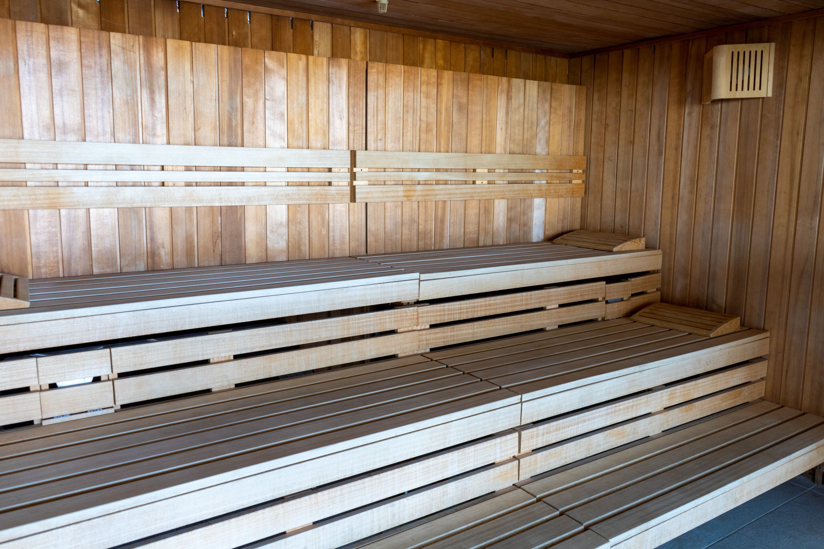 Una sauna con bancos de madera y suelo inclinado.