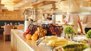 A buffet with fruits, vegetables, and various dishes.