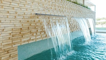 Swim in style surrounded by a unique brick wall design and lush greenery.