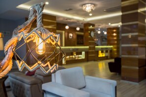 A modern lobby with a geometric light fixture, a reception desk, and a seating area. - Formback Thermal Hotel Bursa (Bursa)