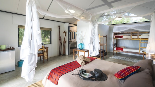 Un dormitorio con cama, escritorio, silla, armario y ventana.
