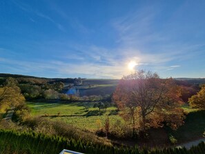 A panoramic view of a countryside landscape with rolling hills, a river, and a clear sky. - Hotel Zur Morschbach (Altlay)