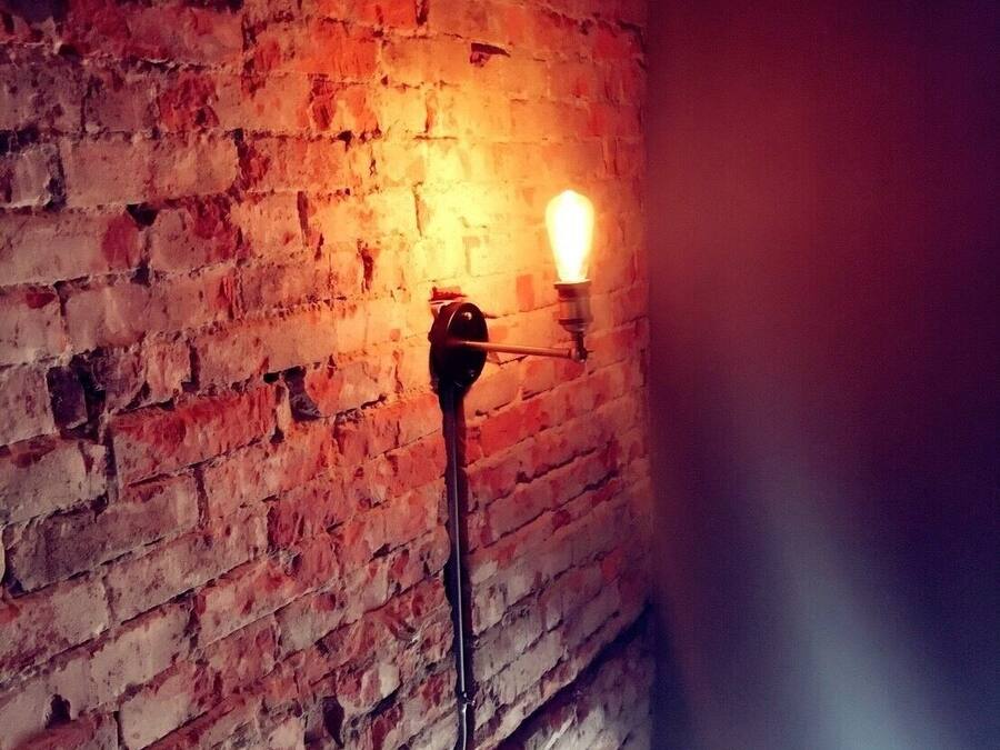 Un muro in mattoni con una singola lampada.