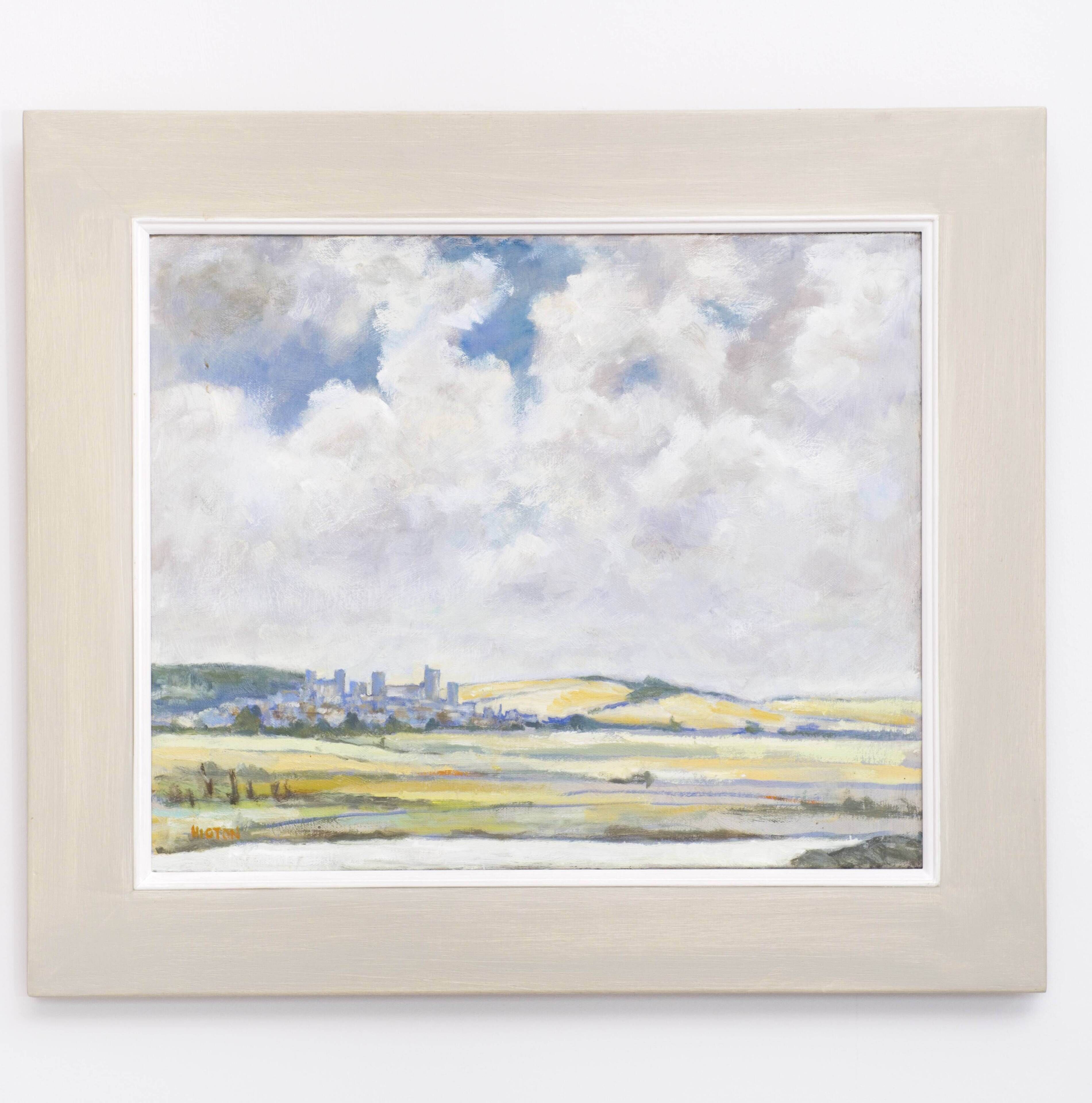 Een lijst met een landschapspainting van een stad met gebouwen en een bewolkte lucht.