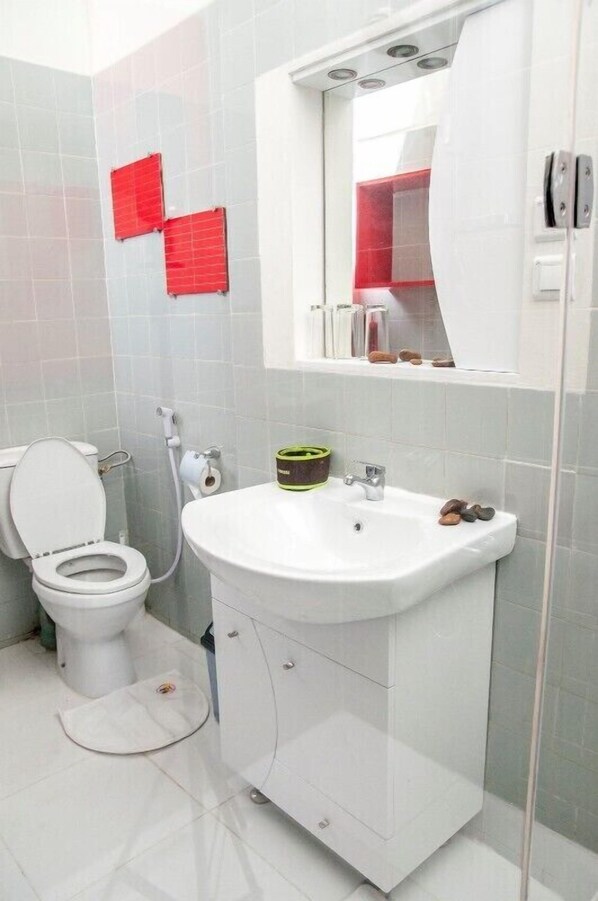 Une salle de bain avec des toilettes, un lavabo et un miroir.