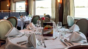 A dining table set with white tablecloth, silverware, and a menu card. - Select MS Serenity - Neuss (Neuss)