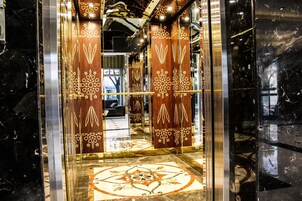 Un ascensor con superficies reflectantes y paneles decorativos.
