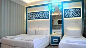 Habitación de hotel con dos camas, una mesita de noche y paneles decorativos en la pared.