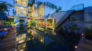 A modern hotel with a rooftop pool, outdoor seating, and a staircase leading to the upper levels. - VIHARA The City of Temples (Siem Reap)