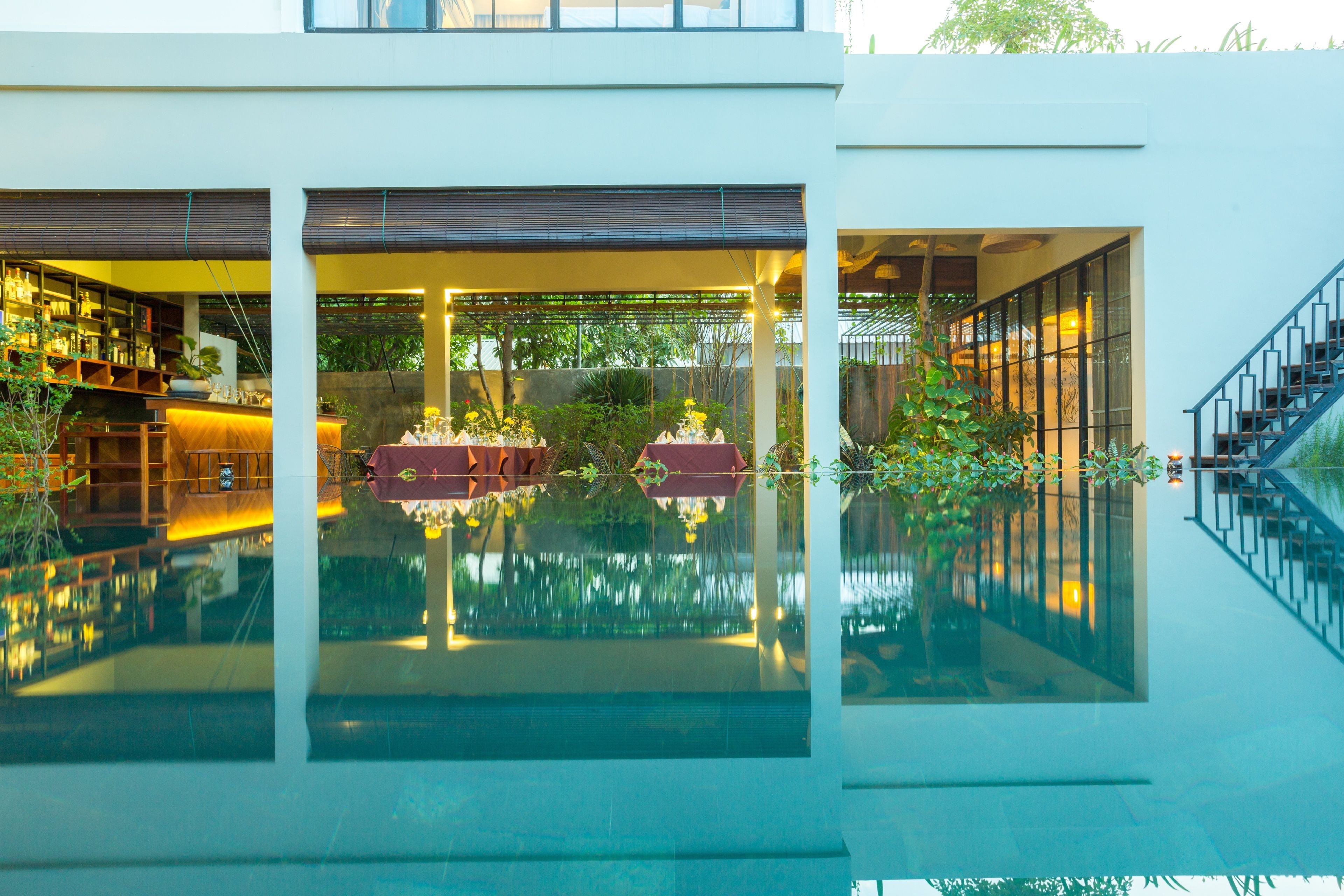 Een buitenzwembad, parasols bij het zwembad en ligstoelen