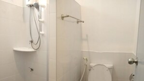 A small, white bathroom with a toilet, a shower, and a sink. - Blue Hip Apartment Nakhon Sri (Nakhon Si Thammarat)