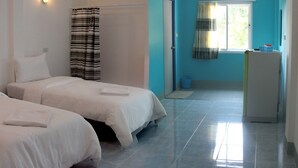 A hotel room with two beds, a window with curtains, a small kitchenette, and a bathroom with a shower curtain. - Blue Hip Apartment Nakhon Sri (Nakhon Si Thammarat)