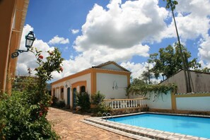 Una piscina al aire libre, sillones reclinables de piscina
