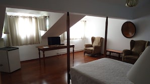 A bedroom with a bed, a desk, a chair, and a television. - Pousada Richard Rothe (Tiradentes)