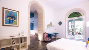 A bedroom with a bed, a desk, a chair, and a shelving unit. - Palazzo Gilistro (Syracuse)