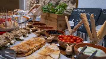 Un buffet proposant une variété de plats, notamment des sandwichs, des salades et des bâtonnets de pain.