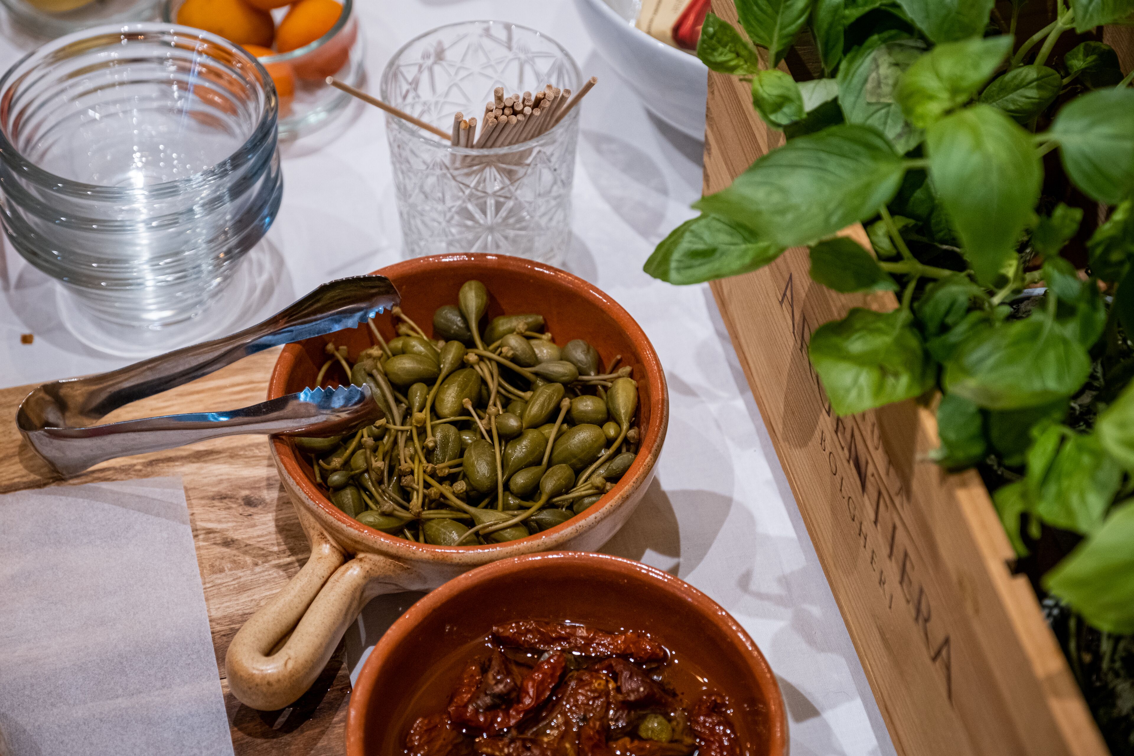 A table with bowls of food, a glass, and a plant.