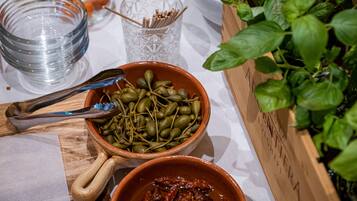 A table with bowls of food, a glass, and a plant.