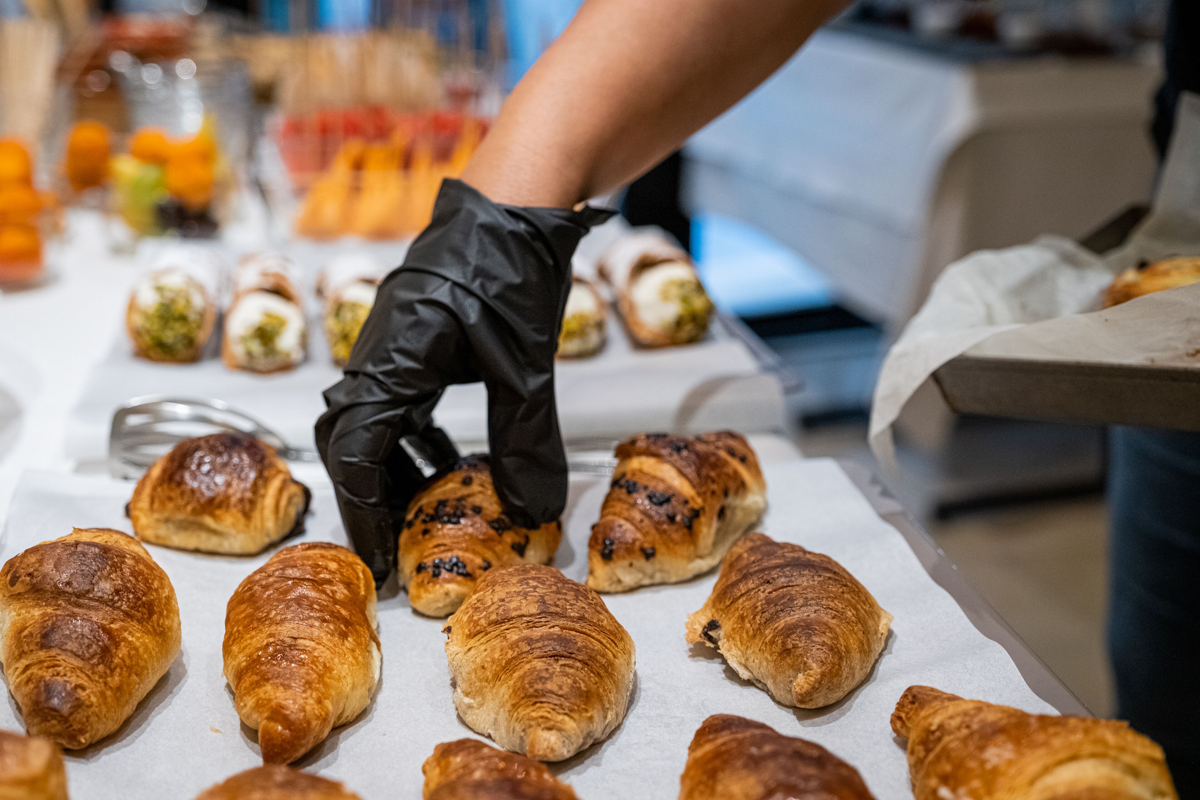 A tray of assorted pastries, including croissants and filled pastries, on a table.