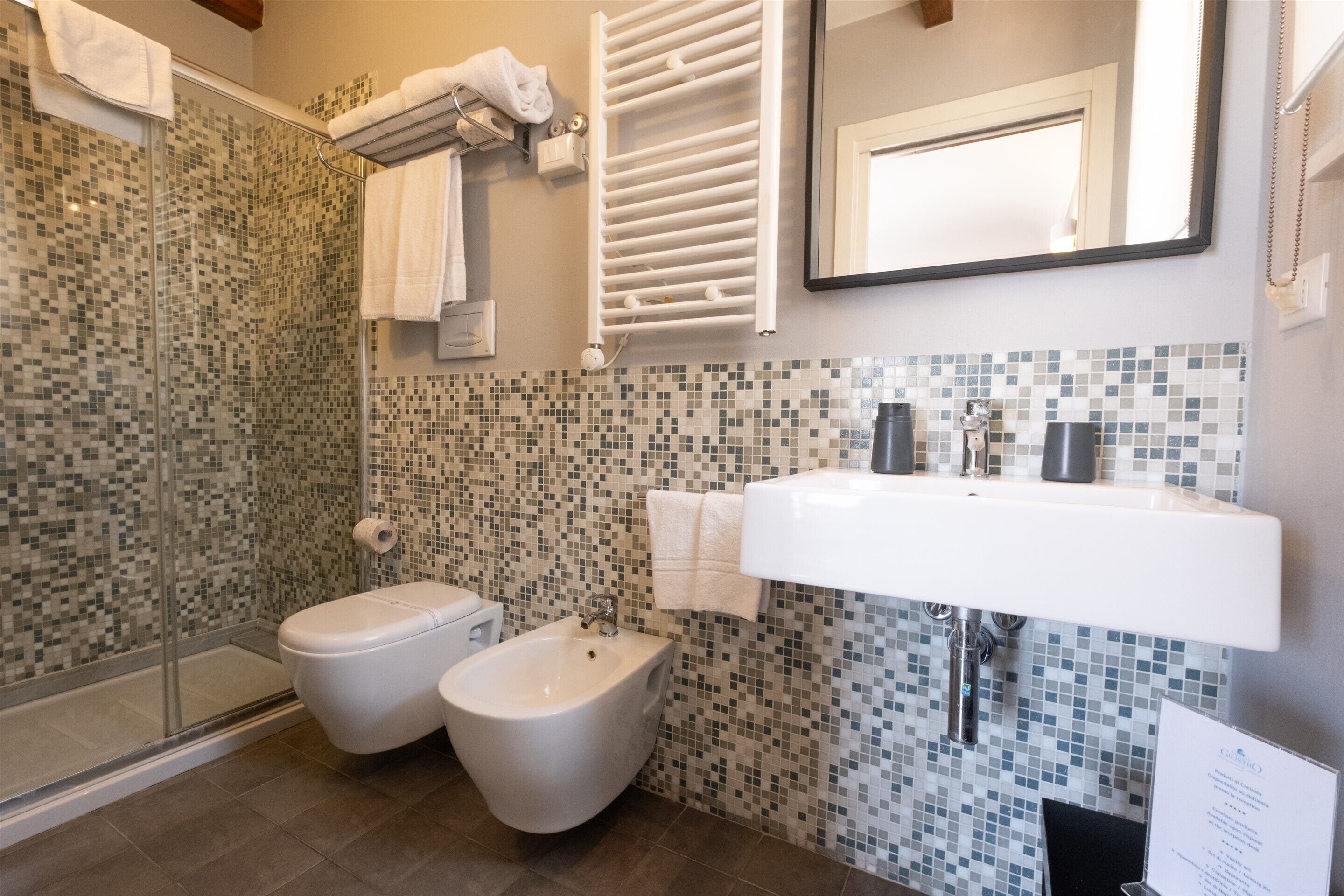 A modern bathroom with a shower, bidet, and sink.