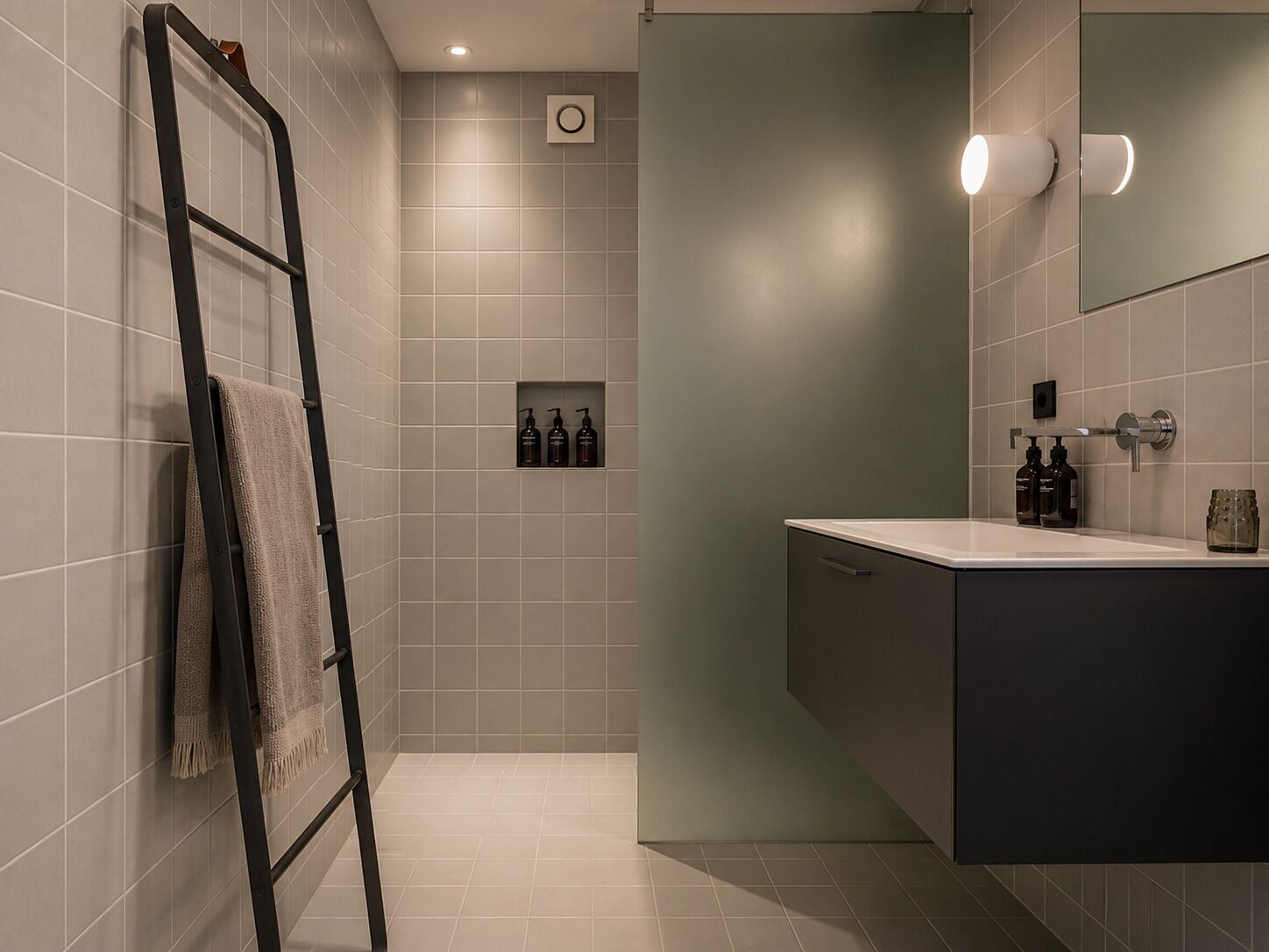 A modern bathroom with a shower, a towel rack, a mirror, and a shelf with toiletries.