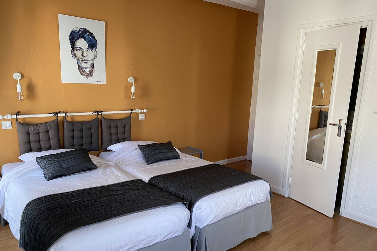 A double bed with a headboard, two bedside tables, and a wall-mounted light fixture.
