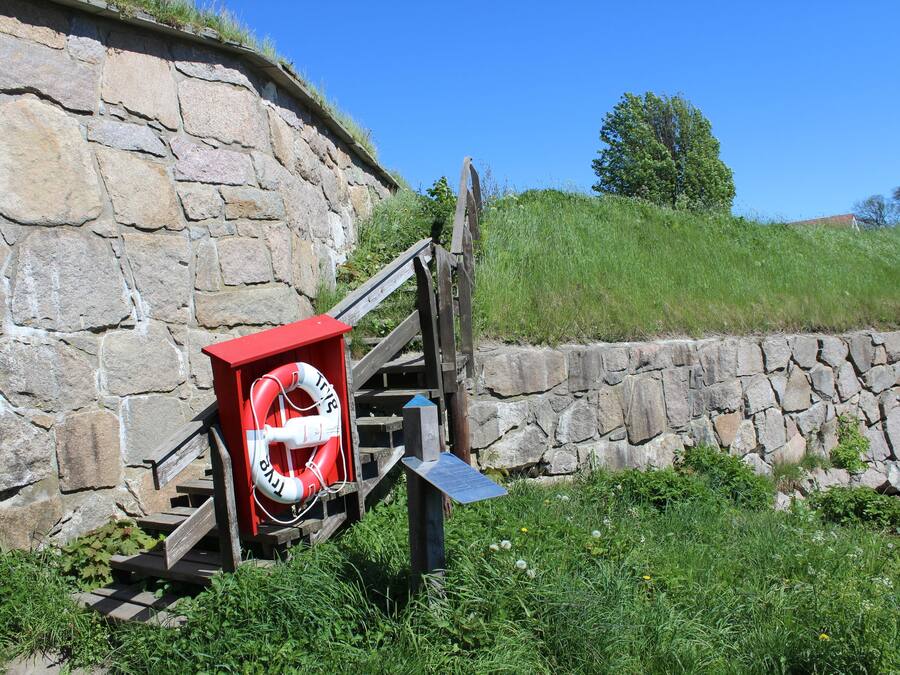 Eine Steinsäule mit einem Rettungsring, der an einer Holzkonstruktion befestigt ist.