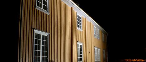 A two-story building with vertical siding and multiple windows.