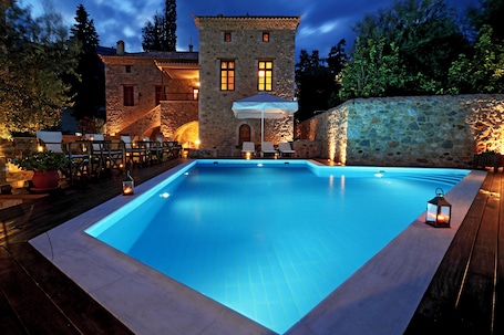 Una piscina al aire libre, sombrillas, sillones reclinables de piscina