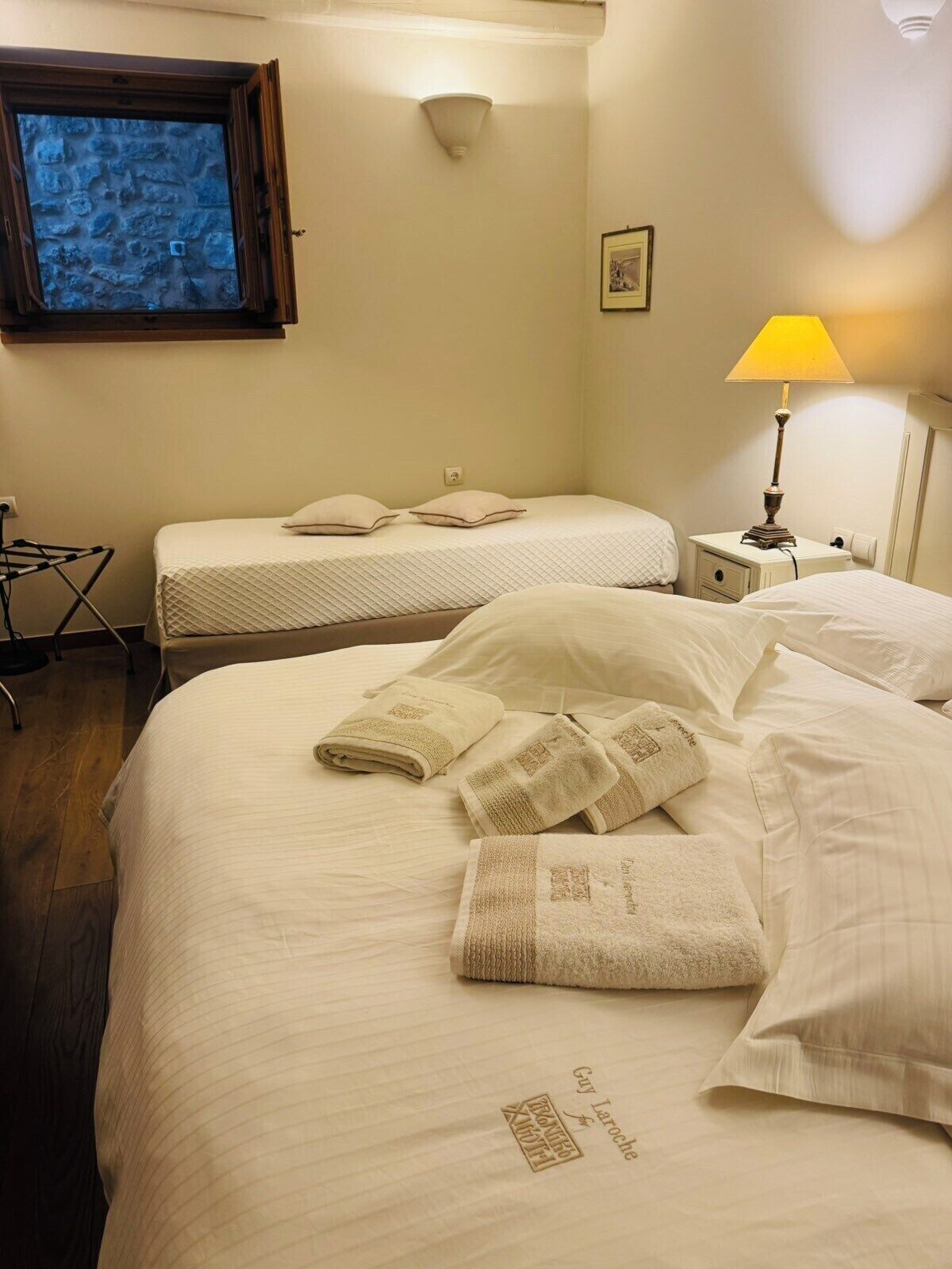 Une chambre d’hôtel avec deux lits, une télévision, une lampe et une petite table.