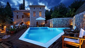 A stone building with a pool and outdoor seating. - Archontiko Chioti (South Kynouria)