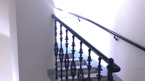 A staircase with ornate black balusters and a handrail, leading to a landing. - Heart of Vienna Harmoniegasse (Vienna)