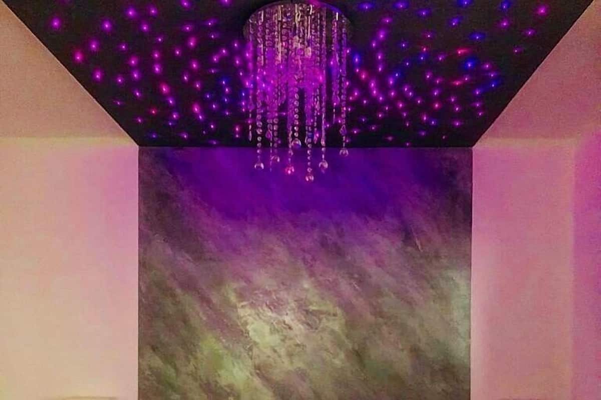 Ein Schlafzimmer mit einem großen Bett, einer Lüster und einer strukturierten Wand.