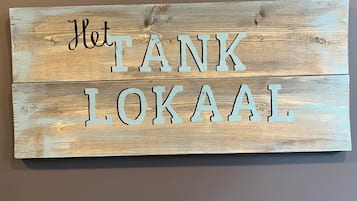 A wooden sign with the text "Het TANK LOKAAL" in capital letters.