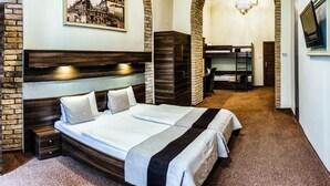 Un dormitorio con una cama grande, un cabecero de madera, un arco de piedra, una araña y un cuadro en la pared.