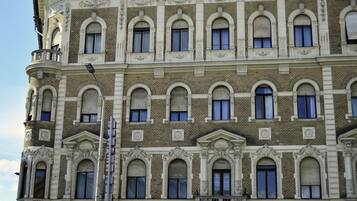 A multi-story building with a classical architectural style, featuring arched windows and decorative moldings.