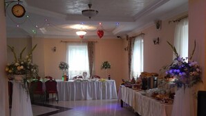A banquet hall with tables set for a formal event, decorated with flowers and a variety of dishes. - Dom gościnny Gerus (Lubomierz)