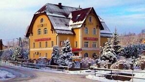 A yellow building with two visible signs, one reading "Pensionhaus" and another "Ski & Spa Resort". - Dom gościnny Gerus (Lubomierz)