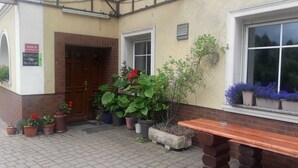A building with a reception area, a wooden door, and potted plants. - Dom gościnny Gerus (Lubomierz)