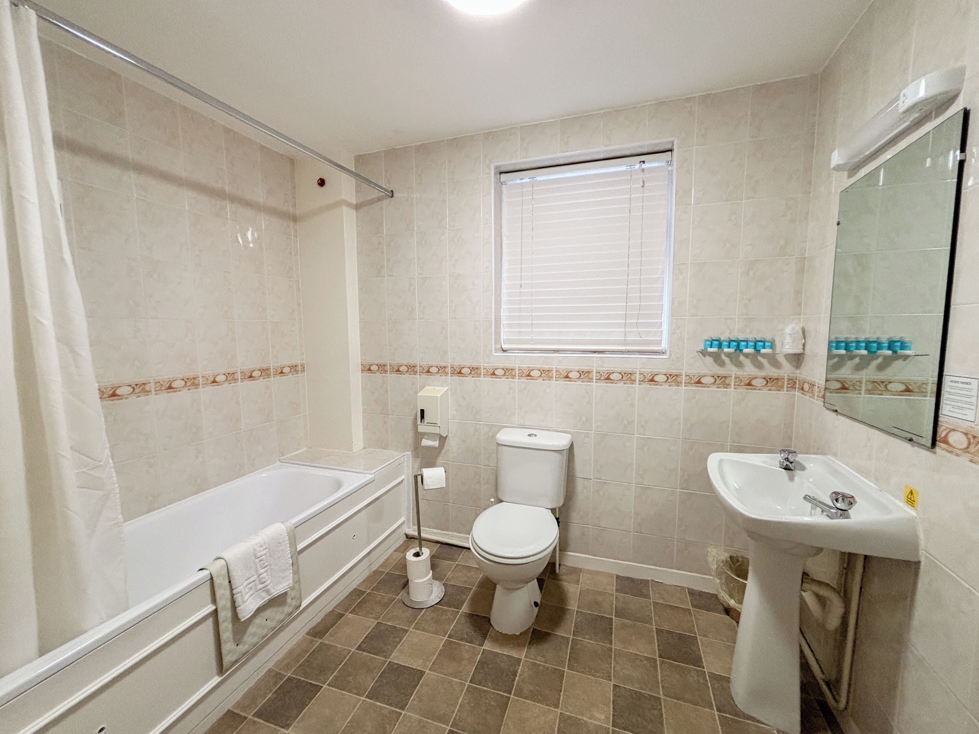 A bathroom with a bathtub, toilet, and sink.