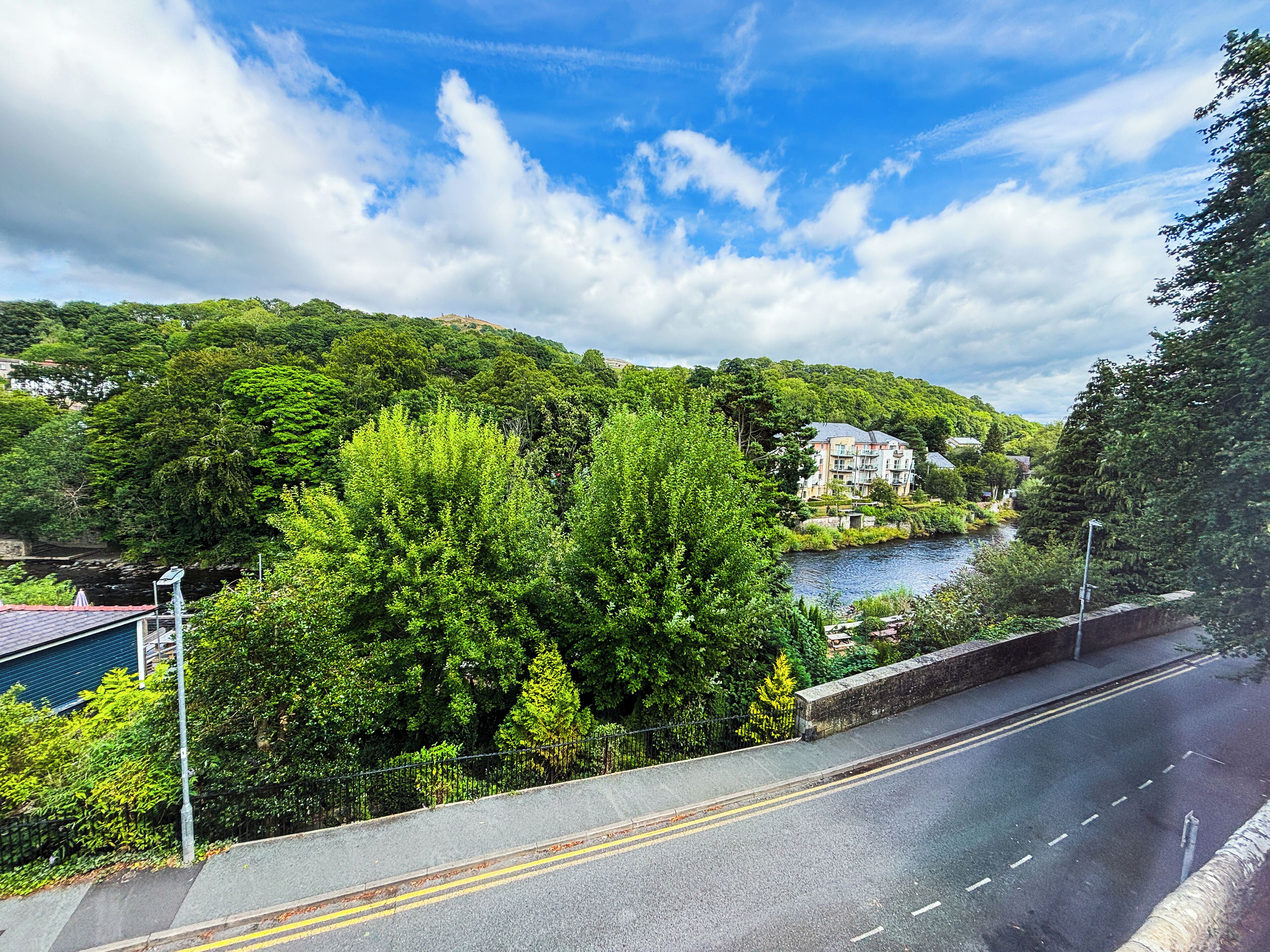 A road with a river and hills in the background.